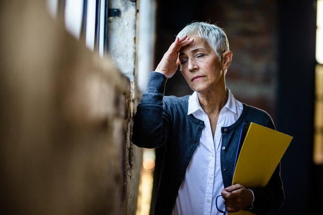 Senior businesswoman experiencing a headache from low sodium levels