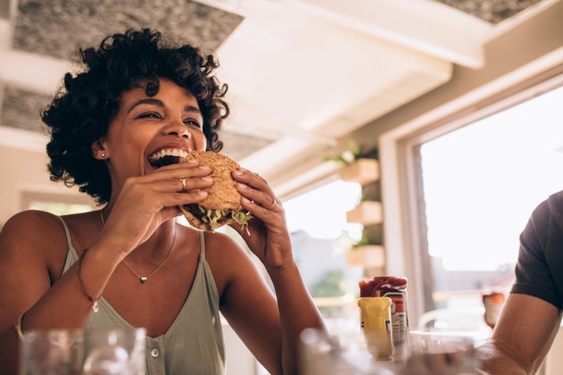 Woman enjoying eating a burger at a restaurant