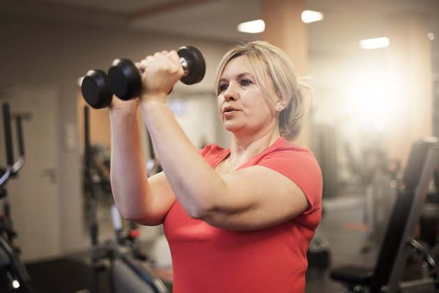 Woman doing upper-body workout at the gym to burn fat