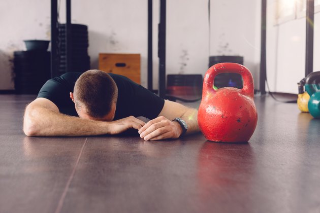 Sportsman lying down on the gym floor