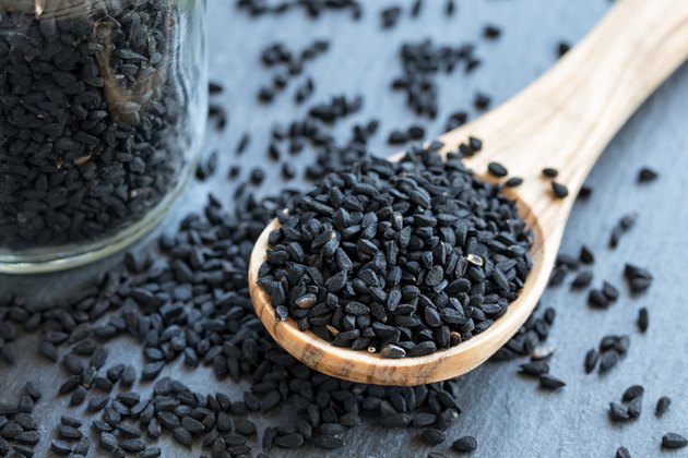 Black cumin seeds on a wooden spoon