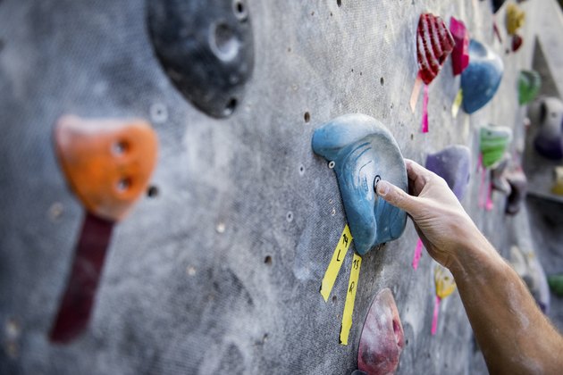 Cropped image of athlete holding rock on climbing wall