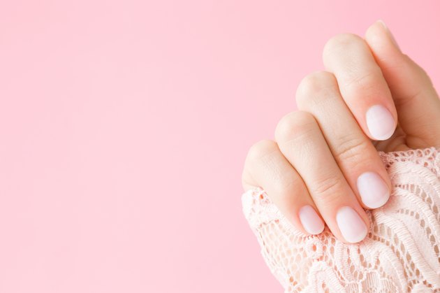 Beautiful, perfect, groomed woman's hand with light pink nails on the pastel background. Manicure, pedicure beauty salon concept. Empty place for text or logo.