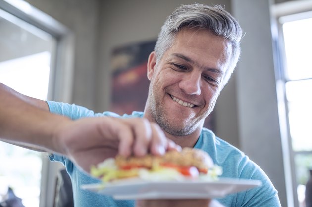 A man eating a sandwich for lunch at home
