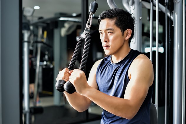 强大的英俊亚洲男子在健身房锻炼