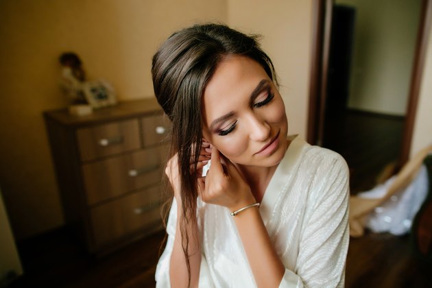 Beautiful bride wears an earring.