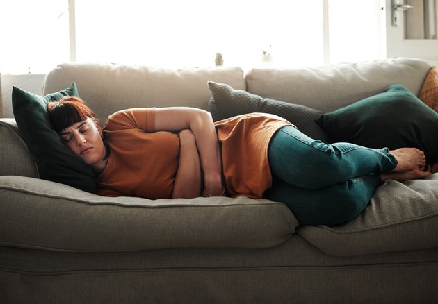 Woman feeling sick on the couch.