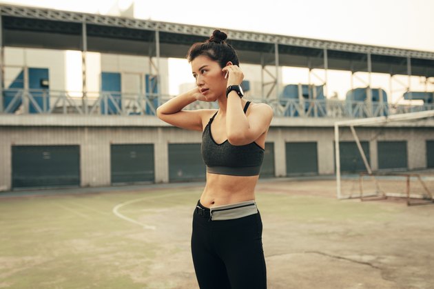 Portrait of a Runner: Fit Asian Woman With Wireless Earphones Ready to Run