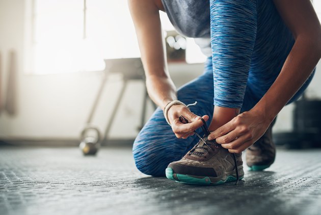 A woman tying her sneakers before a workout
