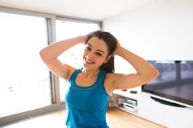 年轻女性在家锻炼，伸长脖子。