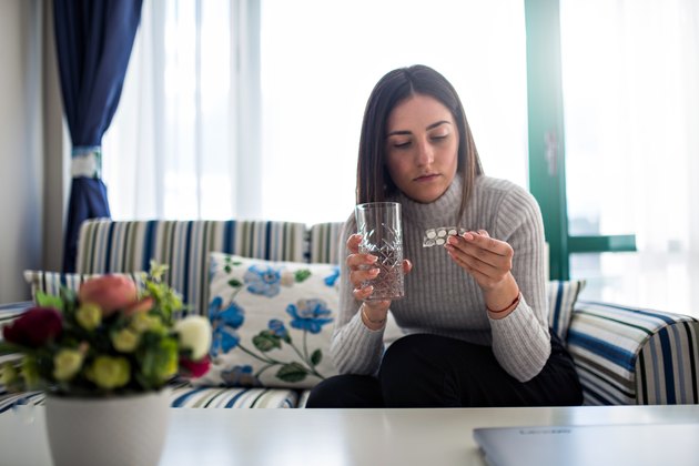 Woman reading pill package.