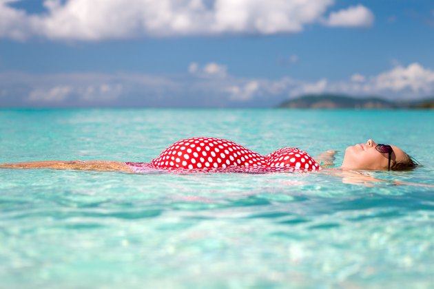pregnant woman floating on water at the Caribbean beach