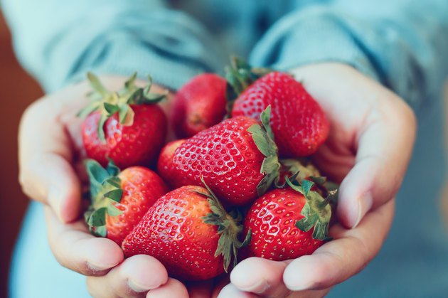 手里拿着一份新鲜草莓