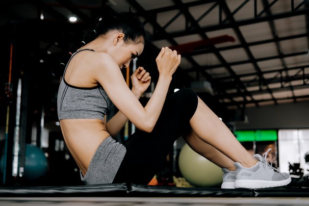 sport woman at fitness gym club doing sit up exercise for body and showing muscle bodybuilding, fitness concept, sport concept"n