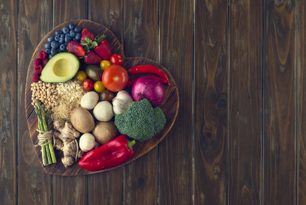 健康的水果和蔬菜在心脏形状切板上