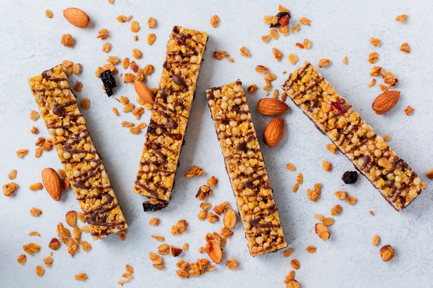 Cereal granola bar with nuts, fruits and berries on a whhite stone table. Granola bar. Healthy snack. Top view.