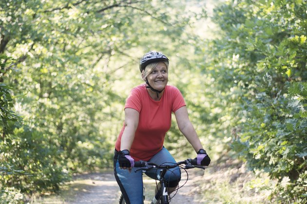 Older woman riding a mountain bike outdoors