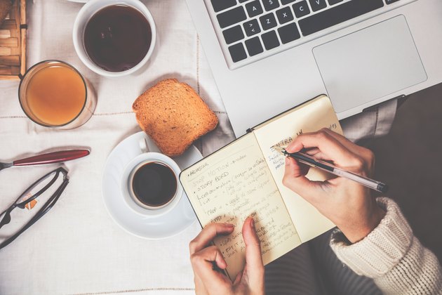Having breakfast in early morning, writing in a food journal