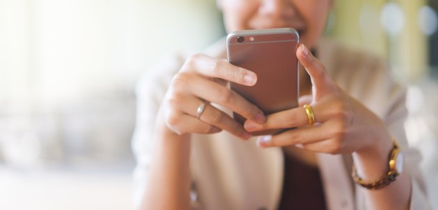 close up young beautiful asian woman looking at smartphone for video online chat with friends or surf the internet or playing mobile application in relax time, millennial technology lifestyle concept