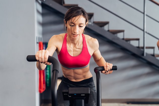 Woman in gym using exercise bike