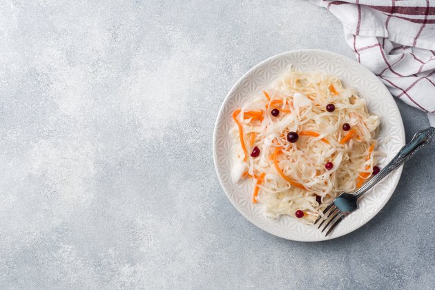 Homemade sauerkraut with carrots and cranberries in plate. Copy space
