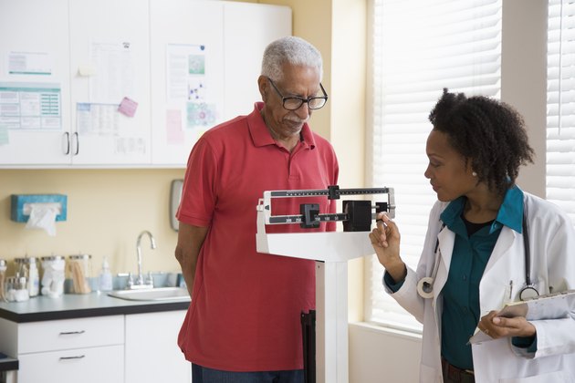 Female doctor weighing a senior man with diabetes
