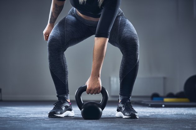 行使与kettlebell的运动妇女特写镜头在健身房