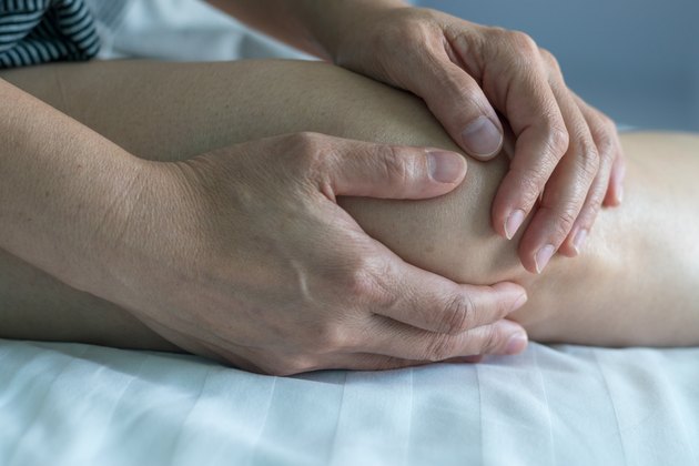 膝关节疼痛疾病概念。手放在腿上，因为关节炎、痛风或感染而受伤。