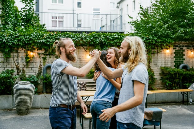 Two Young Guys Pleased To See Each Other At Barbecue Meetup With Friends
