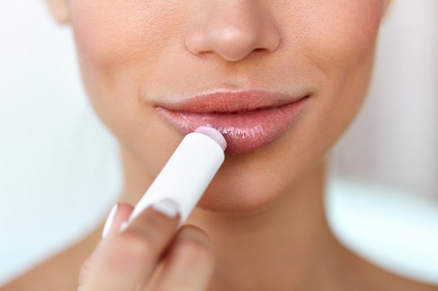 Beautiful Woman Applying Lip Protector On Lips