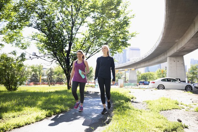 妇女走阳光城市路径