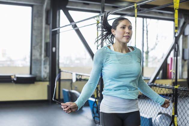 妇女在健身房跳绳，作为间歇性有氧运动的一部分