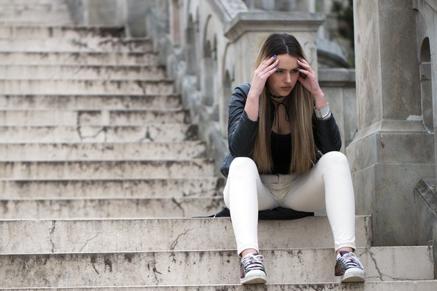 Tensed Woman Sitting On Staircase