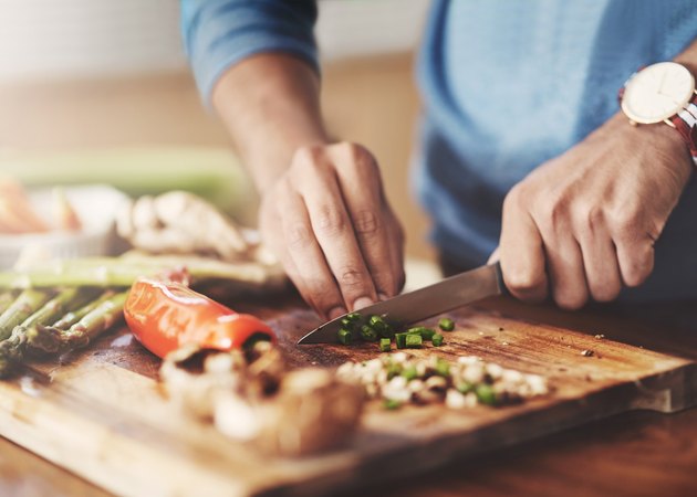 Persons hand cutting vegetables