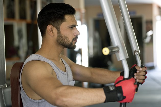 Young man doing chest exercise at gym