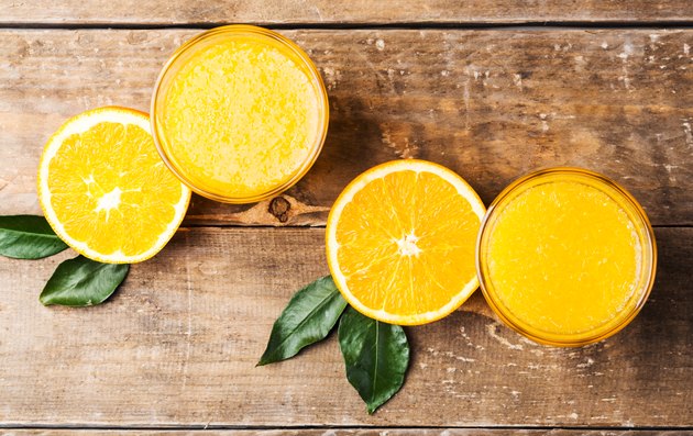 Top view of orange juice and fruits on wooden table