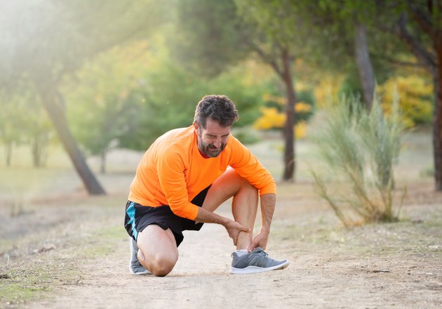 Athletic runner male holding leg with muscle cramp possibly due to potassium deficiency