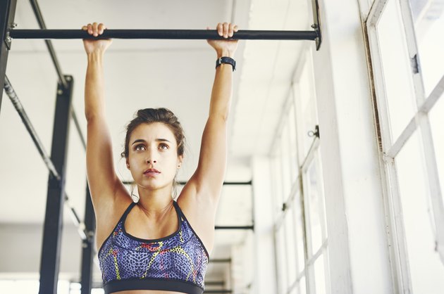 Low angle view of young female trying to do a pull-up