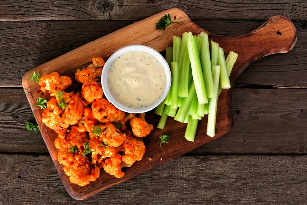 Healthy vegan cauliflower buffalo wings with celery and ranch dip for healthy junk food