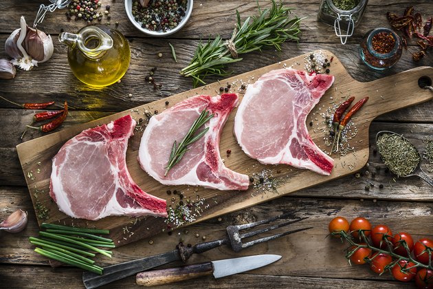 Raw pork loin chops shot from above on rustic wooden table