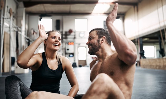 Fit young couple high fiving together after a workout
