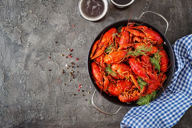 Crayfish. Red boiled crawfishes on table in rustic style, closeup. Lobster closeup. Border design. Top view. Flat lay.