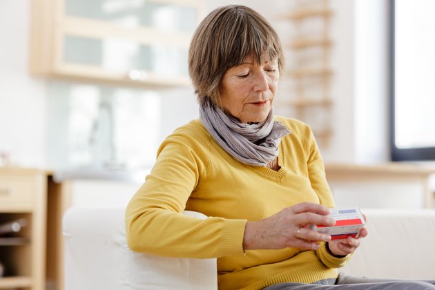 Senior woman reading label on medicine