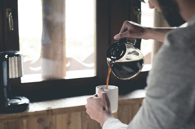 倾吐咖啡的年轻人在家入杯子