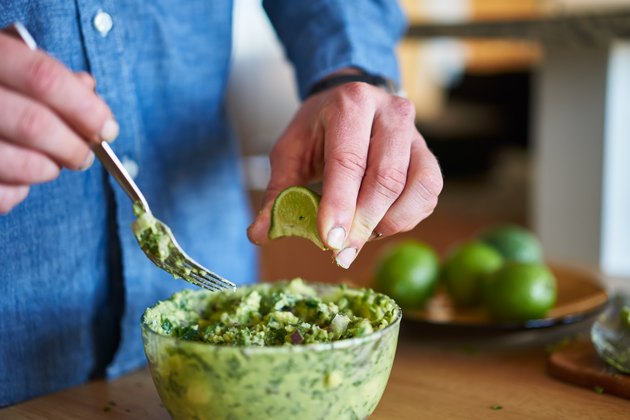 adding lime juice to guacamole