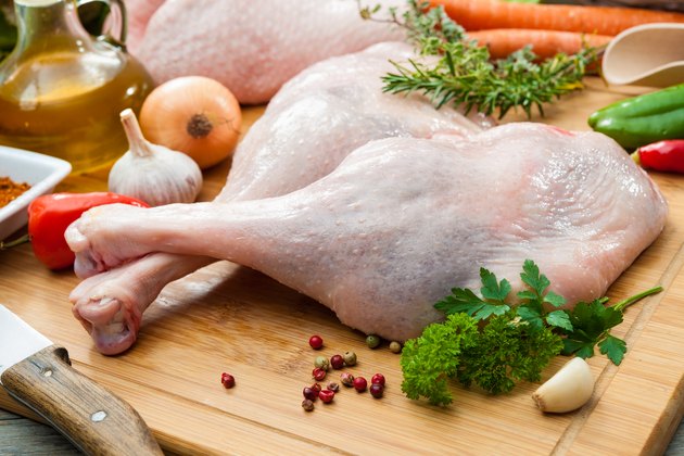 Raw turkey legs on cutting board