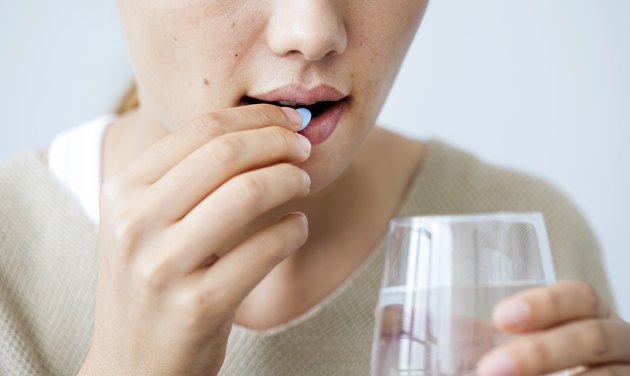 Young woman taking a vitamin