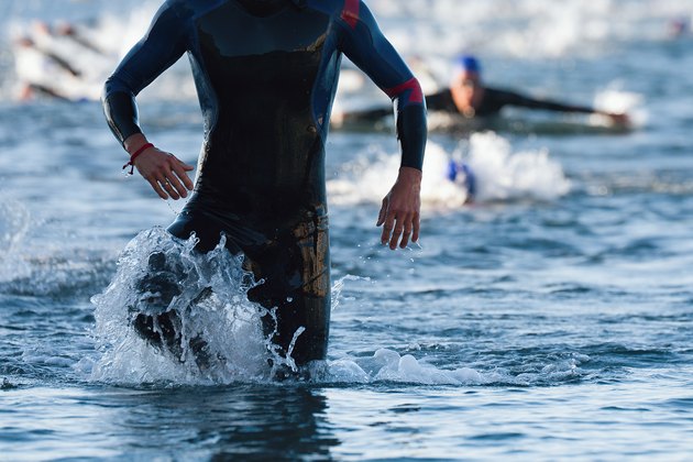 Triathletes running out of the water on triathlon