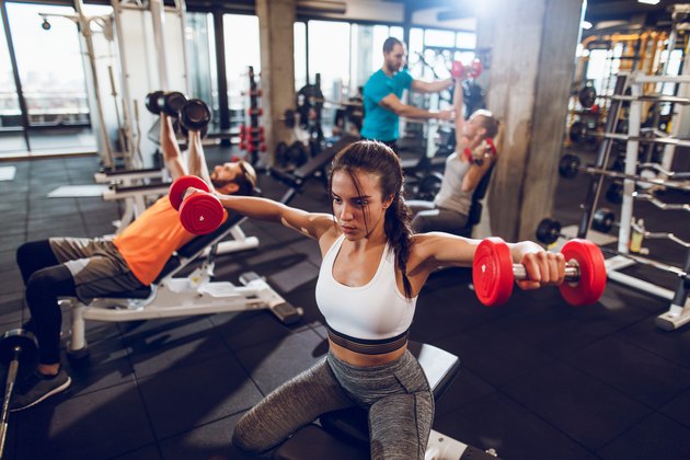 Young sporty woman doing dumbbell exercise at the gym