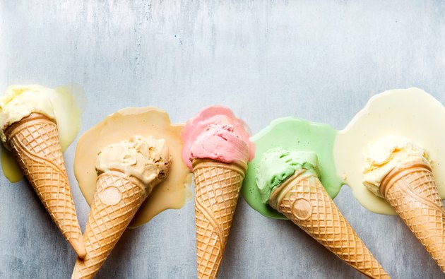 Colorful ice cream cones of different flavors. Melting scoops. Top view, steel metal backgroun